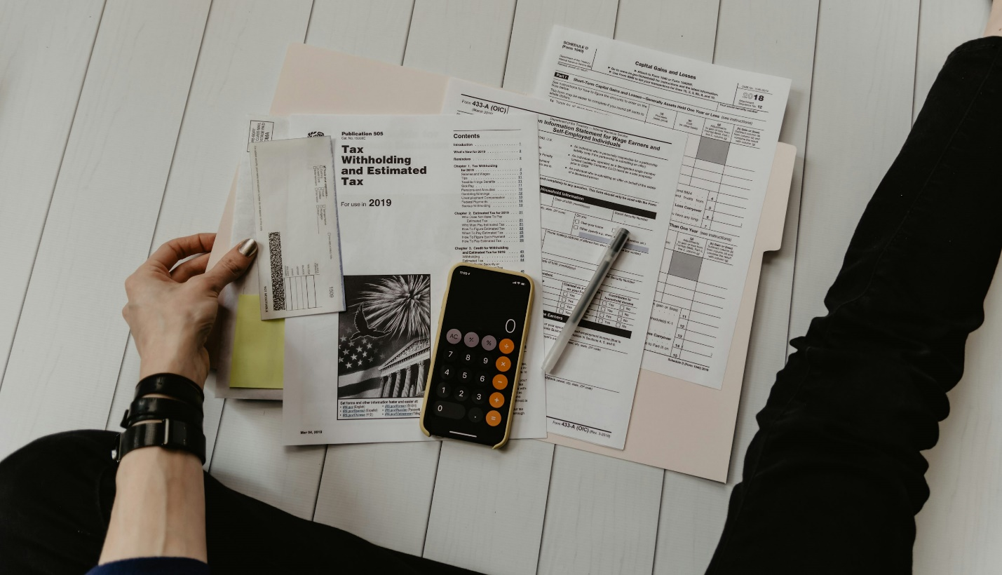 A person sitting with documents and a calculator